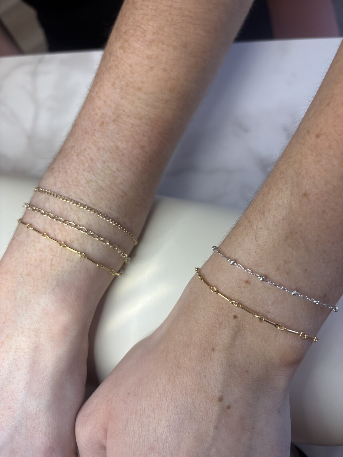 Client wearing a custom permanent jewelry stack